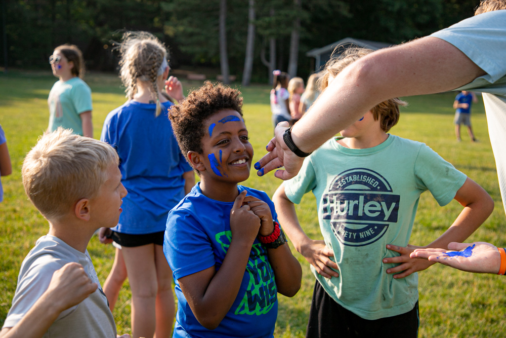 explorer campers with their face paint on for tag games