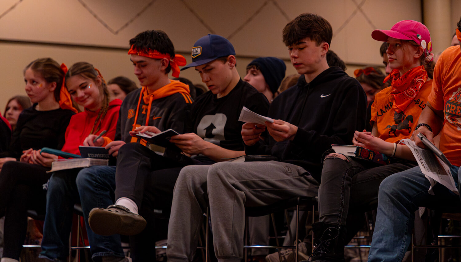 Teens listening to speaker and reading bibles